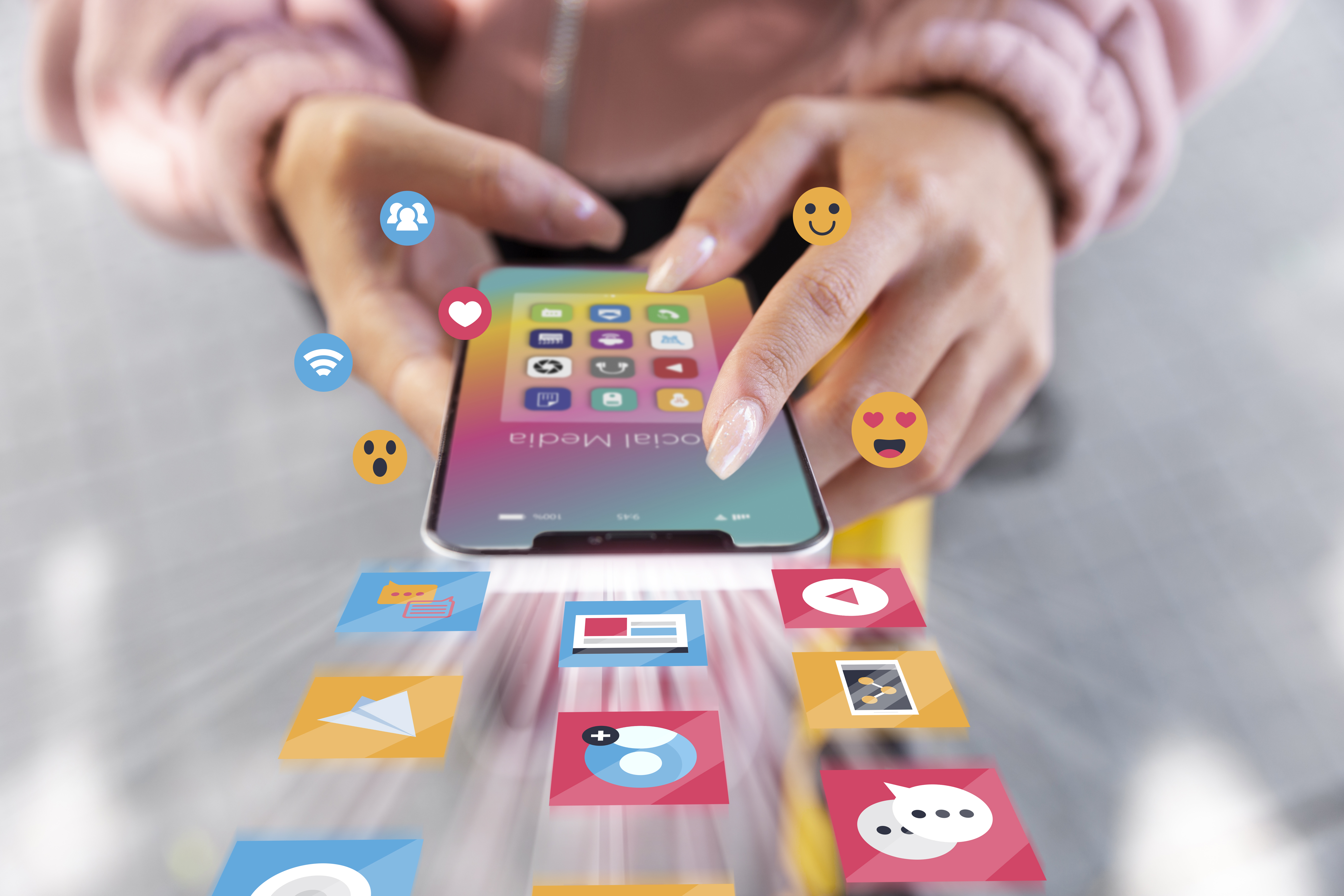 Mulher segurando celular com emojis e logos de redes sociais